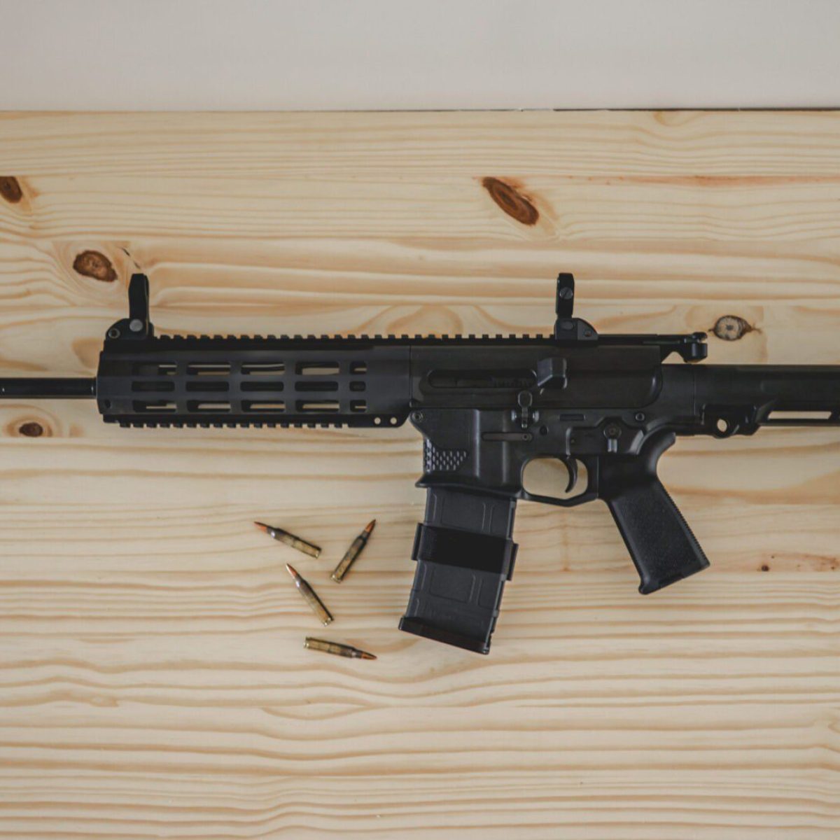 DBR Snake - double barrel AR15 rifle on a white pine board with 5.56 ammo